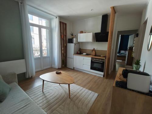 a living room with a table and a kitchen at Logis cosy du centre ville in Aix-les-Bains