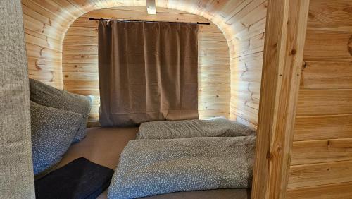 a small room with a bed in a wooden cabin at Camping Schlaffass Naima in Burg