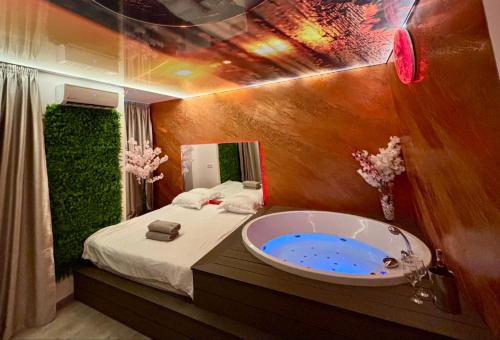 a bathroom with a bath tub next to a bed at MATTEO room by 50 shades in Baia Mare