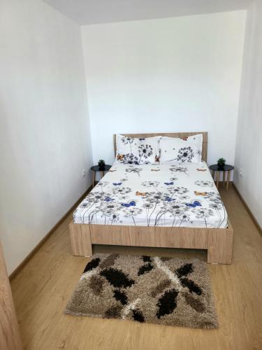 a bedroom with a bed with a comforter and a rug at Studio Cristina in Hunedoara