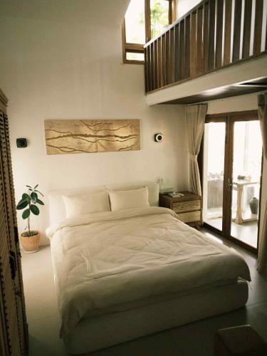a bedroom with a large bed and a plant at Yên homestay in Phan Rang–Tháp Chàm