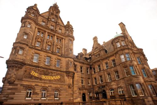 a large brown building with a sign on it at The Scotsman Hotel in Edinburgh