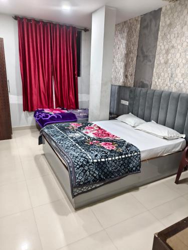 a bedroom with two beds and a red window at Hotel Relax Inn in Madikeri