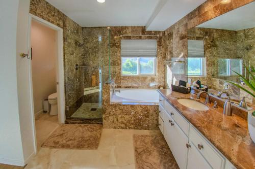a bathroom with a tub and a sink and a shower at Pool & Yard Games! Group Retreat in La Quinta in La Quinta