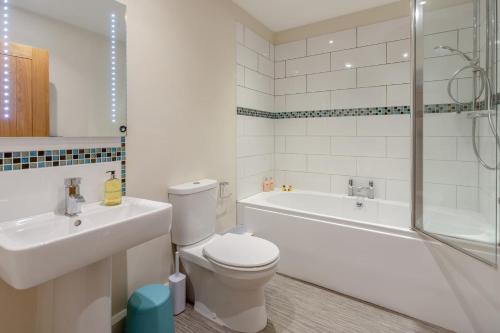 a bathroom with a toilet and a tub and a sink at 2 Bed in Bideford oc-32240 in Parkham
