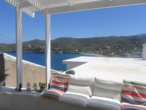 a white couch sitting on top of a balcony at Hidesign Athens Traditional Stone House in Kea's Port in Korissia