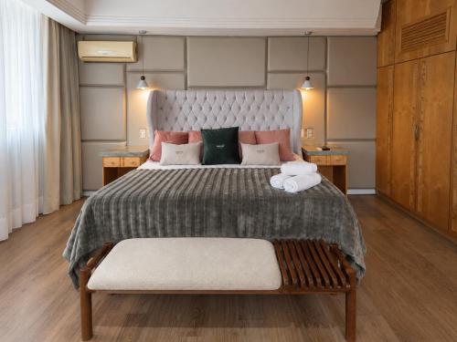a large bedroom with a large bed with two tables at Novo Santoni Hotel Guarapuava in Guarapuava