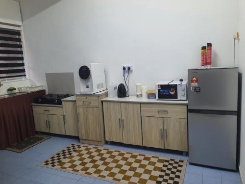 a kitchen with a checkered floor in the middle at De'Garden 12 in Alor Setar
