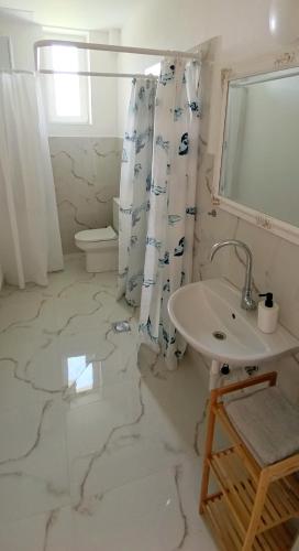 a white bathroom with a sink and a toilet at Vila Kele in Tvrdošovce