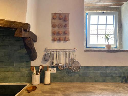 a kitchen with a counter with utensils and a window at Casa do Chafariz in Torres Vedras