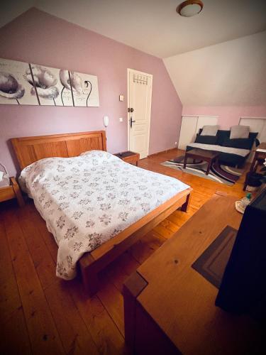 a bedroom with a bed and a couch at Maison Fleurie in Aubertin