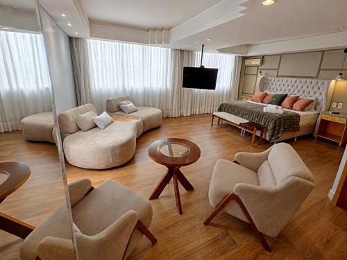 a living room with two couches and a tv at Novo Santoni Hotel Guarapuava in Guarapuava