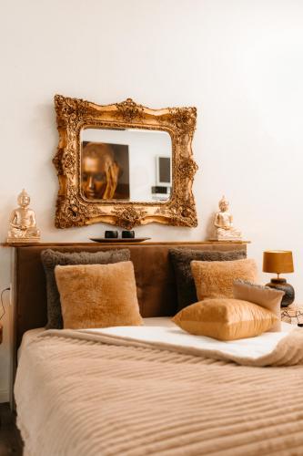 a mirror on the wall above a bed with pillows at Feines Feriendomizil Waldzauber 2 Horhausen Westerwald in Horhausen