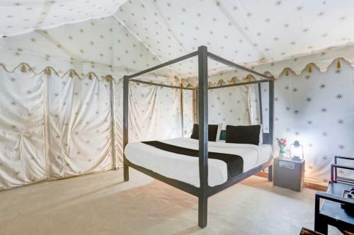 a bedroom with a canopy bed in a tent at The Jungle Enclave Boho in Khilchipur