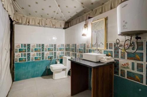 a bathroom with a toilet and a sink at The Jungle Enclave Boho in Khilchipur