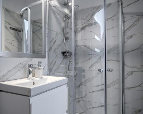 a white bathroom with a sink and a shower at Gościniec Sarnówka 