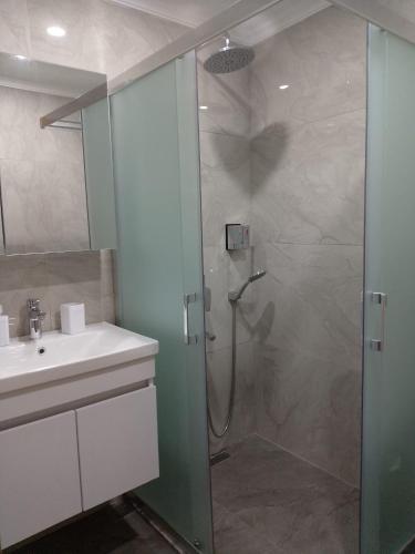 a bathroom with a glass shower with a sink at Fethiye Apart Otel in Fethiye