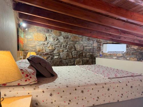 a bed in a room with a stone wall at La Casa Nuova in Chios