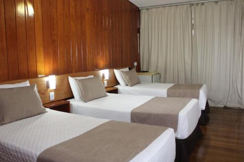 a hotel room with two beds with lights on them at Hotel Tijuco Turismo in Diamantina