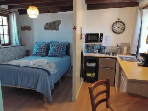 a small bedroom with a bed and a kitchen at La Petite Grange in Langourla