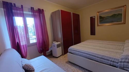 a bedroom with a bed and a window with purple curtains at Il Nido nel Borgo in Piediluco