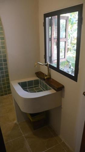 a sink in a bathroom with a window at Sunny Mountain in Ban Nong Hoi