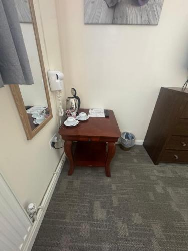 a small wooden table in a room with a mirror at The Goodlife Guesthouse in Harwich