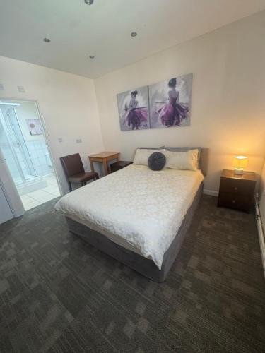 a bedroom with a bed and two pictures on the wall at The Goodlife Guesthouse in Harwich