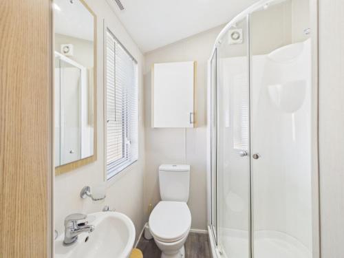 a bathroom with a toilet and a sink and a shower at Pinehurst, 65 Golf View Lodge in Jedburgh