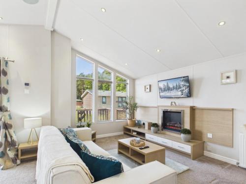 a living room with a couch and a tv at Pinehurst, 65 Golf View Lodge in Jedburgh