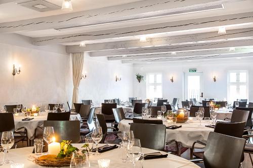 a large room with tables and chairs with white tablecloths at Skanörs Gästgifvaregård in Skanör med Falsterbo