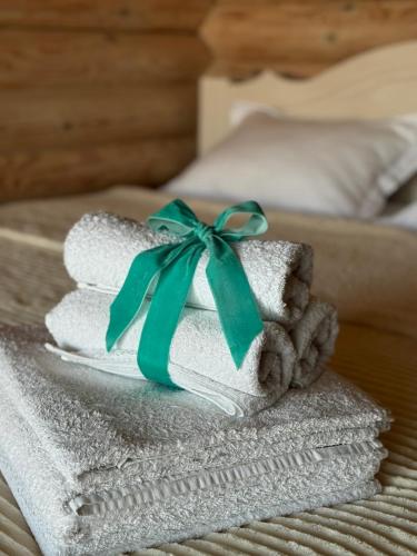 a pile of towels with a green ribbon on a bed at Смерекова хата in Zatoka