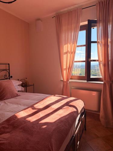 a bedroom with a bed and a window at Liber Barbaresco House in Barbaresco