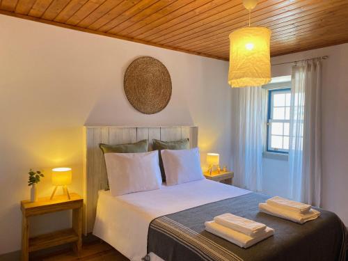 a bedroom with a bed with two towels on it at Casa do Chafariz in Torres Vedras
