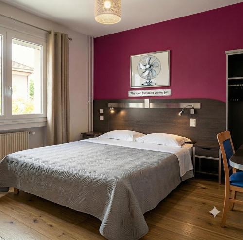 a bedroom with a large bed with a purple wall at Hôtel Au Val De Saône PARKING GRATUIT in Sathonay-Camp