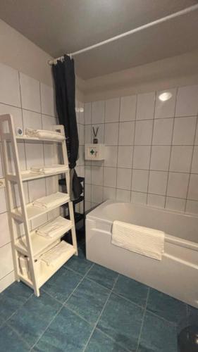 a bathroom with a white bath tub and a ladder at Akranes Sunset Apartment in Akranes
