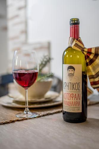a bottle of wine sitting next to a glass of wine at Kyriaki's Cozy Apartments in Agia Marina Nea Kydonias