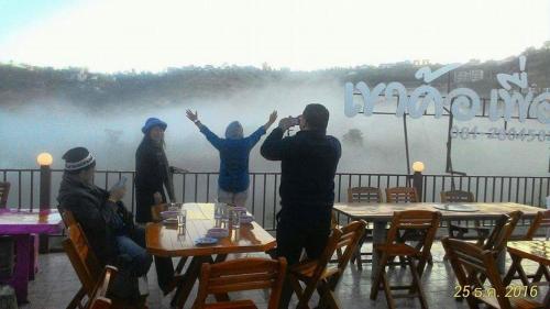 een man die een foto neemt van een groep mensen bij Khao Kho Purngun Resort in Khao Kho