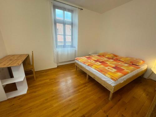 a bedroom with a bed and a table and a window at Apartmán Netolice in Netolice