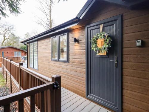 a wooden house with a door and a wreath on it at Luxury 2 Bedroom Lodge at White Cross Bay, Windermere in Windermere