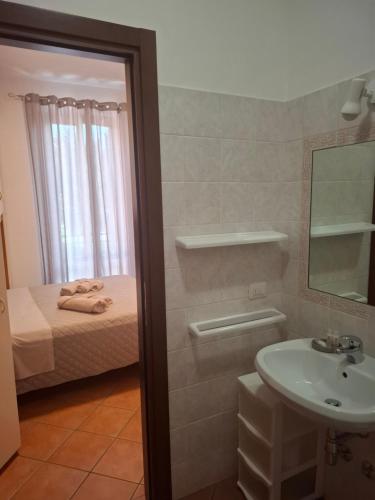 a bathroom with a sink and a bed and a mirror at Cascina Volpi in Montegrino Valtravaglia