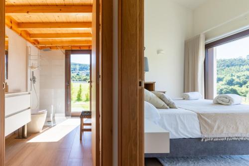 a bedroom with a bed and a large window at A casa das Ías in Tourón