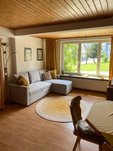 a living room with a couch and a large window at Haus Wäscher in Hirschegg