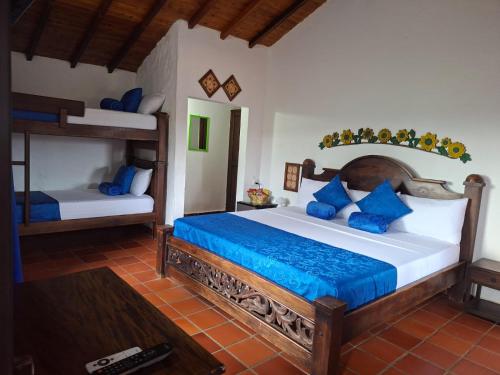 a bedroom with a large bed with blue pillows at Hotel Cristo Rey Campestre in Los Santos