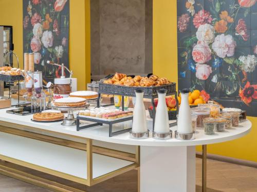a buffet of food on a white table at B&B Hotel Como City Center in Como