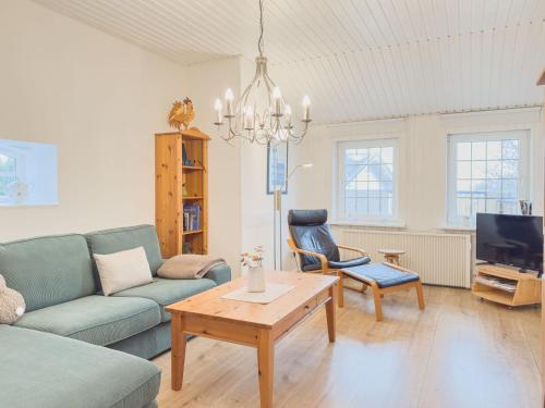 a living room with a couch and a table at Reetdachhaus Sünsbarg in Simonsberg