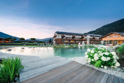 a large pool of water with buildings and flowers at Ferienanlage Central in Flachau