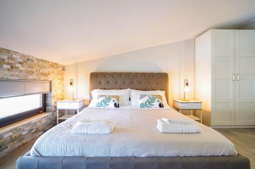 a bedroom with a large white bed with two pillows at Pietra Bianca Rooms in Pachino