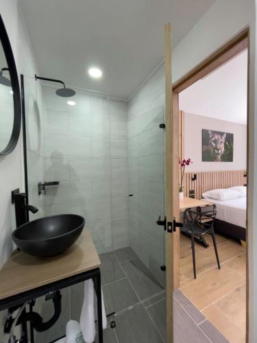 a bathroom with a sink and a glass shower at Vita Hotel Boutique - Aire Acondicionado & Desayuno in Medellín