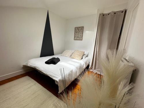 a small bedroom with a bed with white sheets at Studio Cosy & Chic in Angoulême